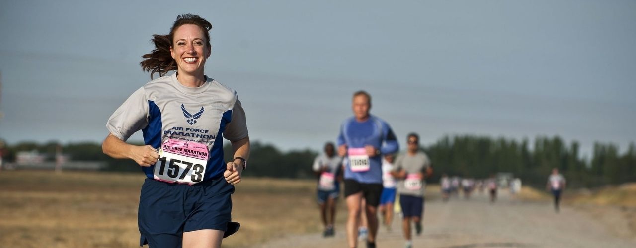 Athlète femme souriante course à pied compétition