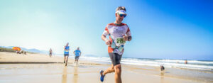 Un homme court sur une plage pendant une compétition de course à pied