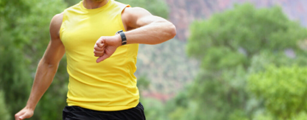Un homme court en regardant sa fréquence cardiaque sur sa montre