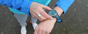 un coureur appuie sur un bouton de sa montre connectée