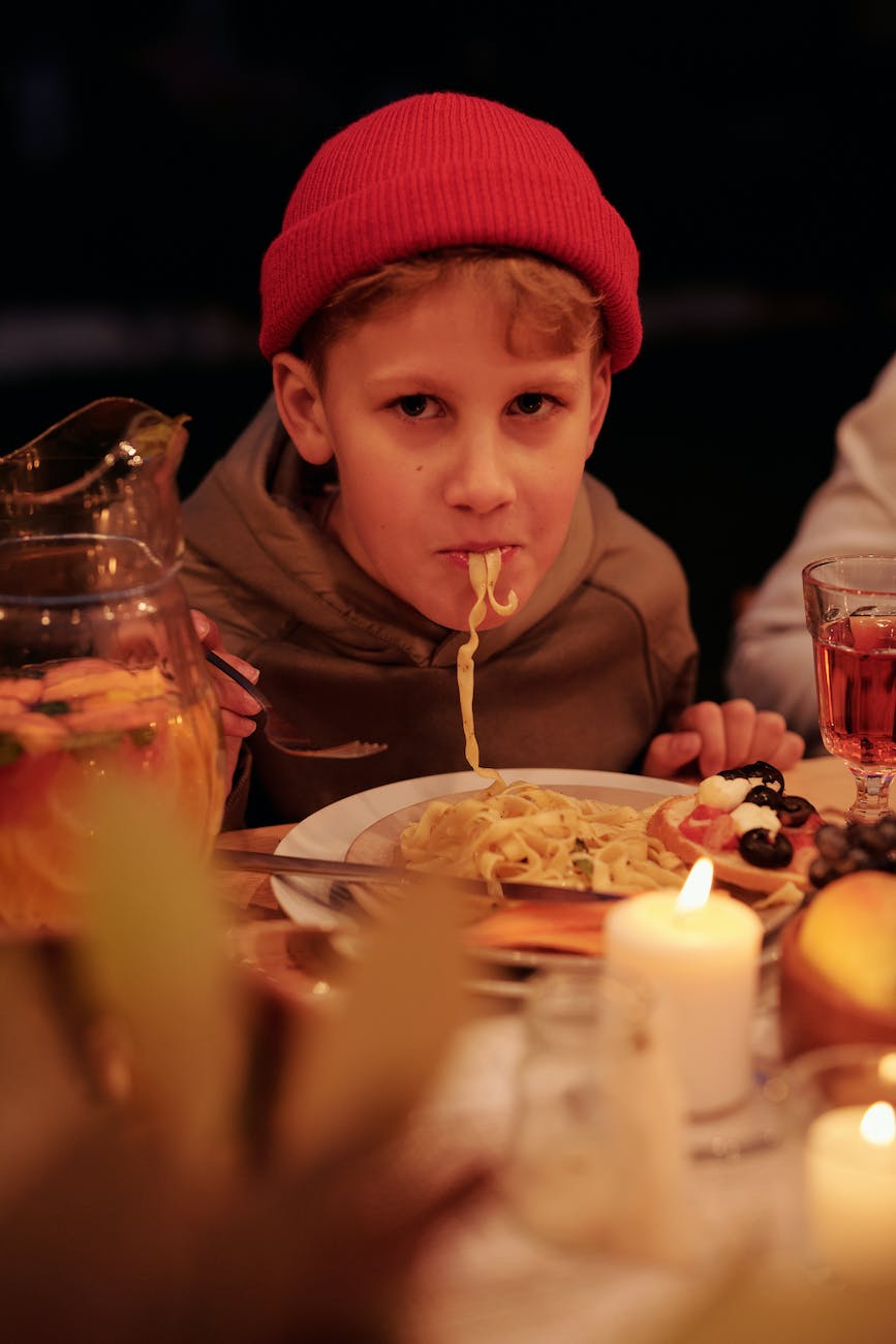 garçon mangeant des pâtes pendant un dîner en famille