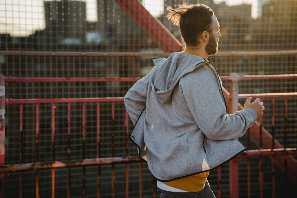 homme courant sur un pont à la lumière du soleil
