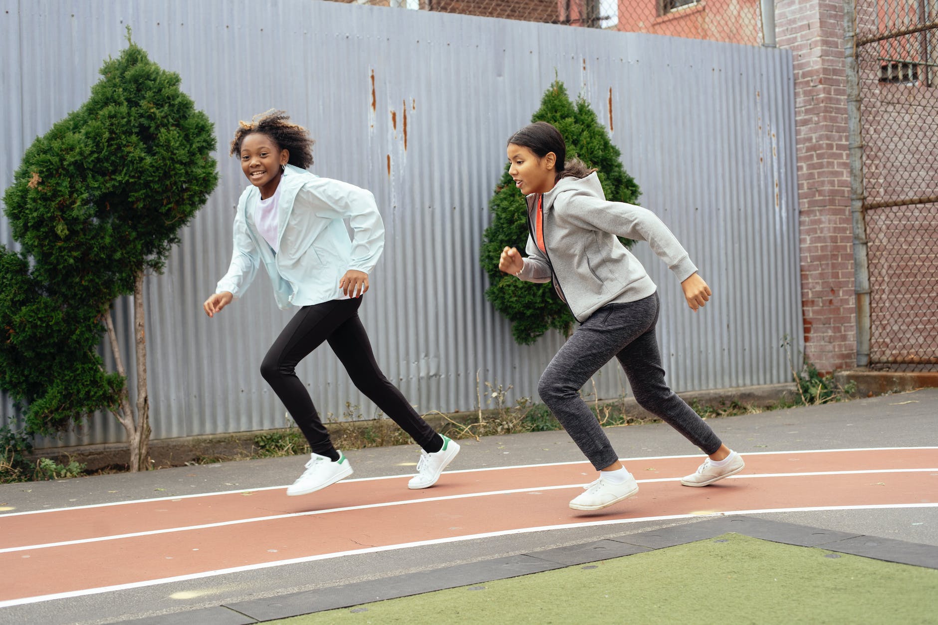 2 filles font la course sur une piste d'athlétisme