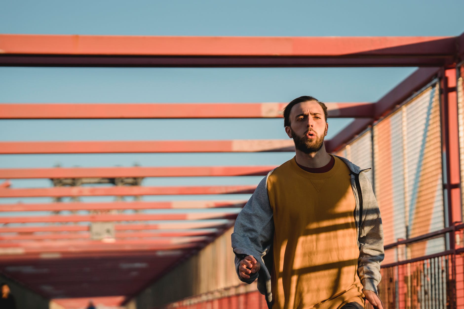 homme courant sur un pont à la lumière du soleil