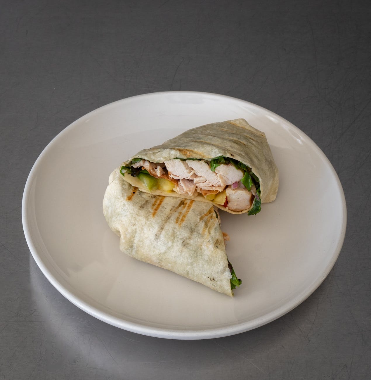 assiette ronde en céramique blanche avec sandwich wrap au poulet
