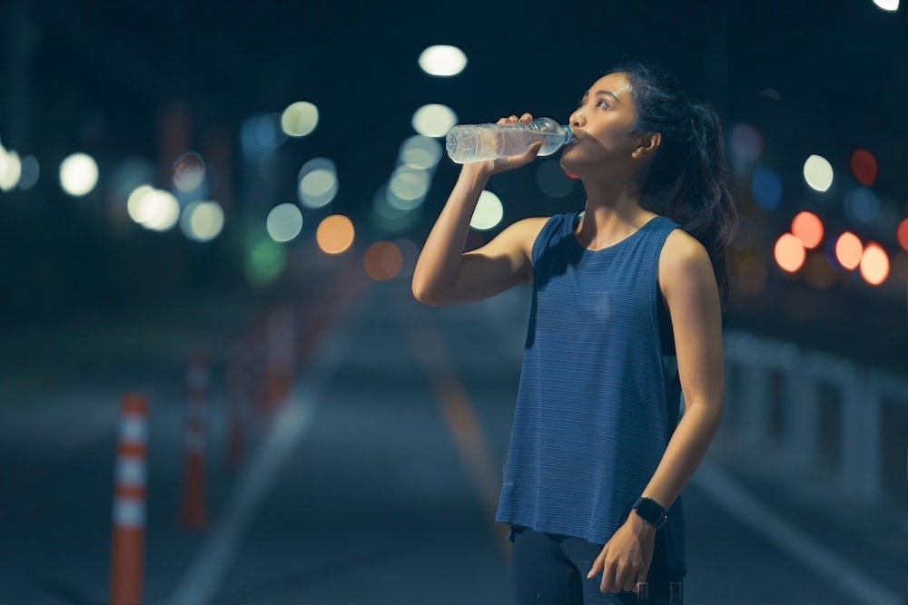 Une marathonienne boit de l'eau