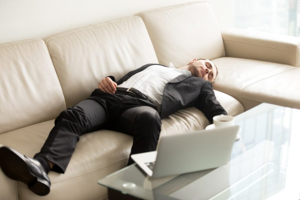 Un homme épuisé dort sur un canapé