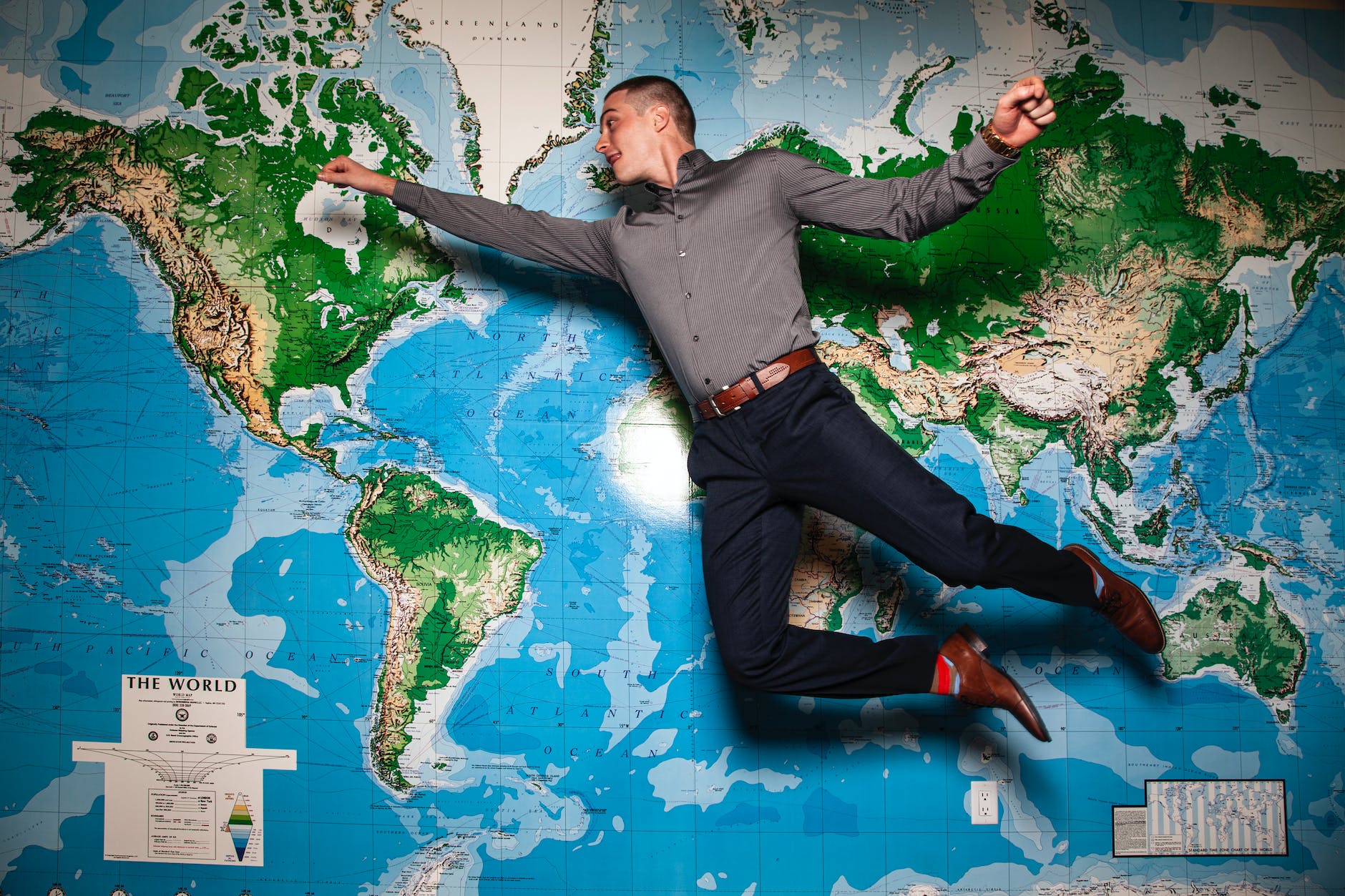 un homme sautant devant une grande carte