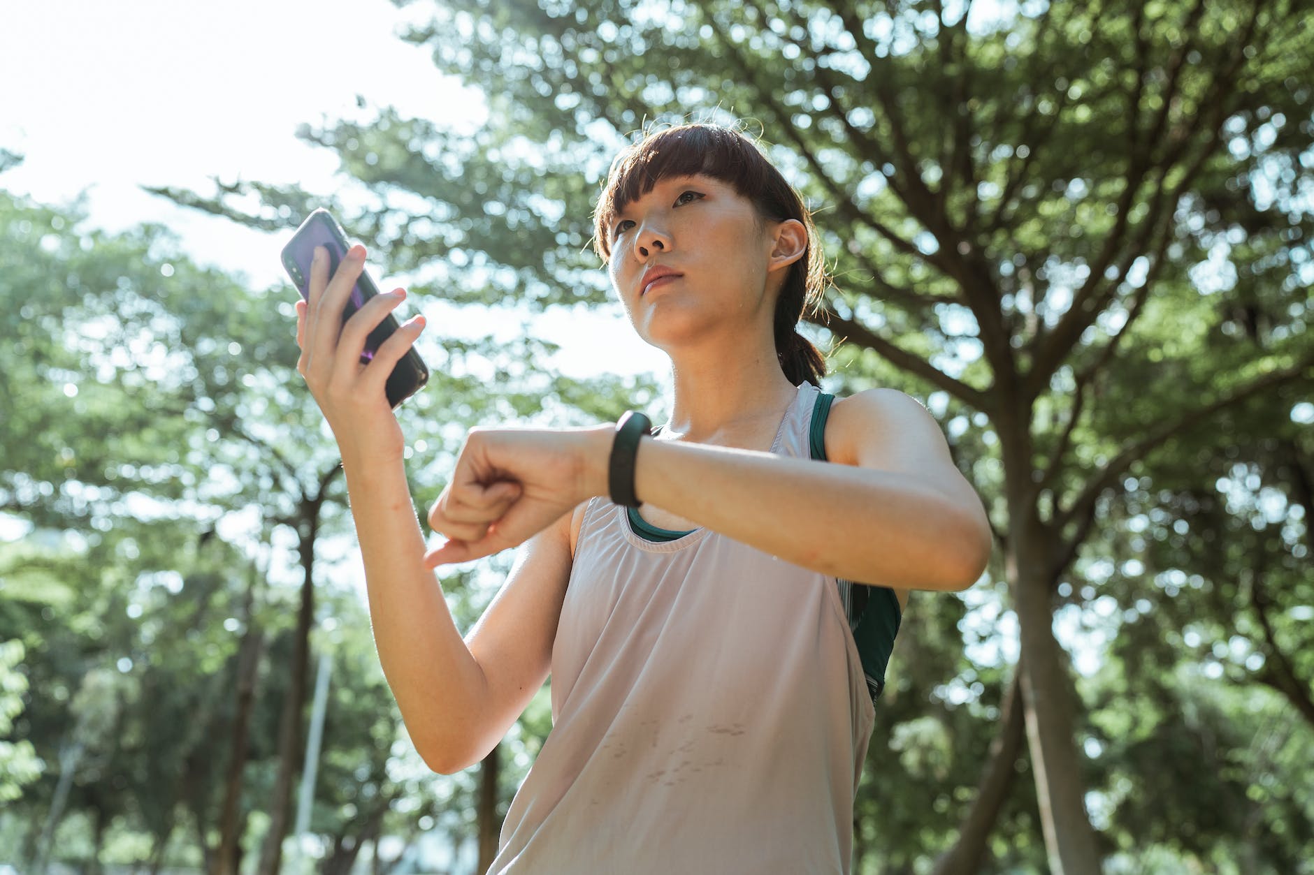jeune femme ethnique connectant un smartphone et une montre intelligente