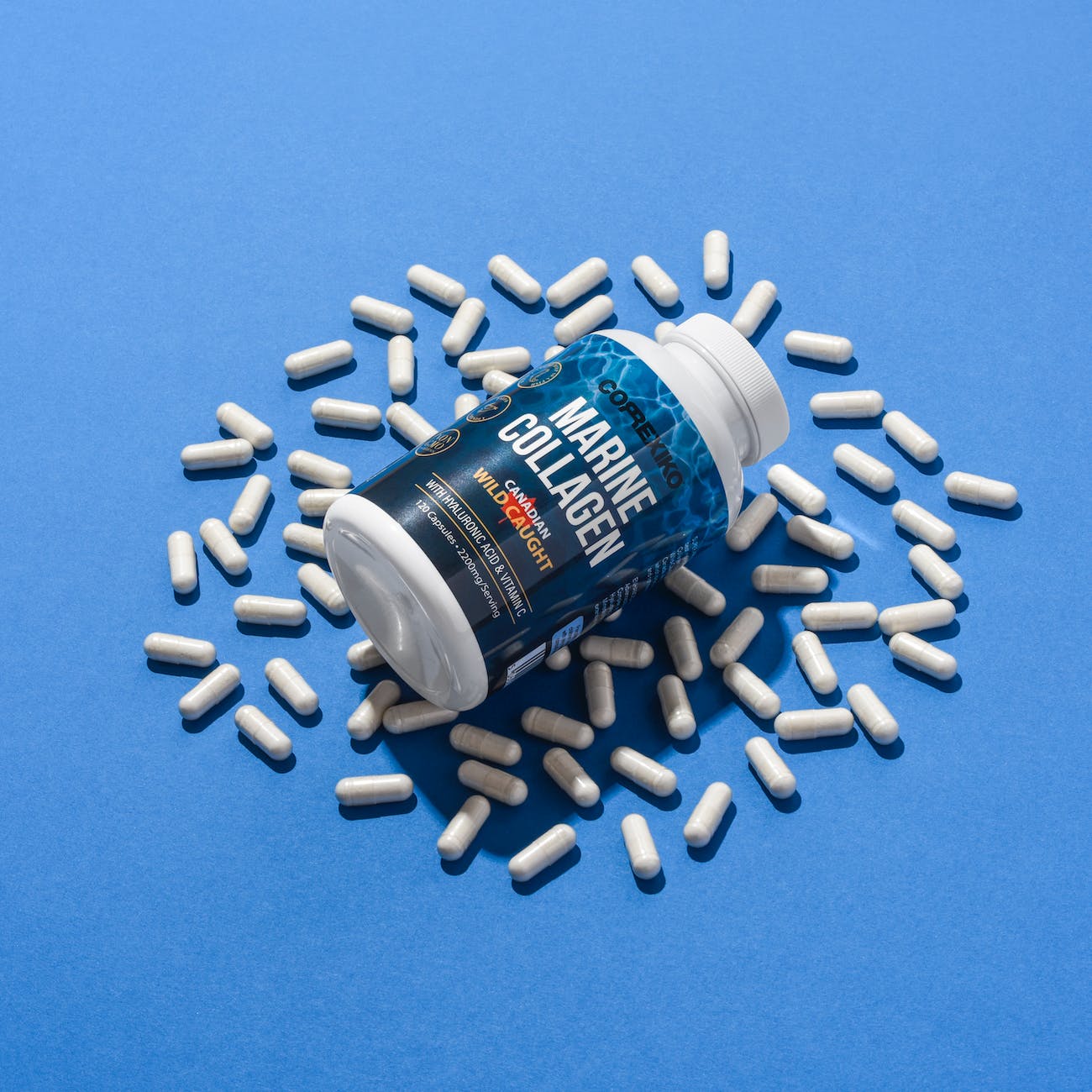 récipient en plastique bleu sur le dessus des gélules de collagène