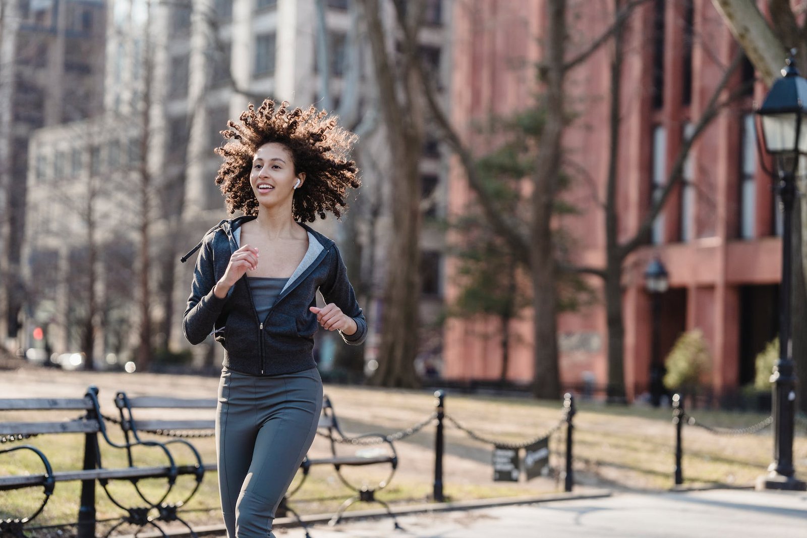 Femme positive courant dans une rue de la ville