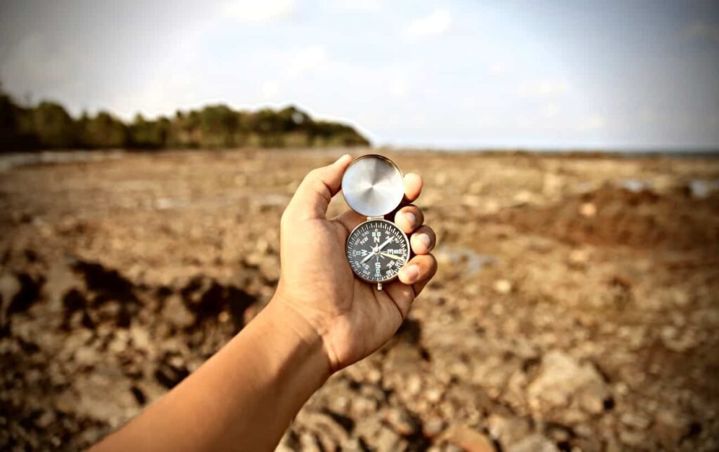Un sportif tient une boussole dans sa main