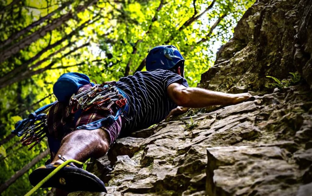 Un homme escalade un bloc rocheux
