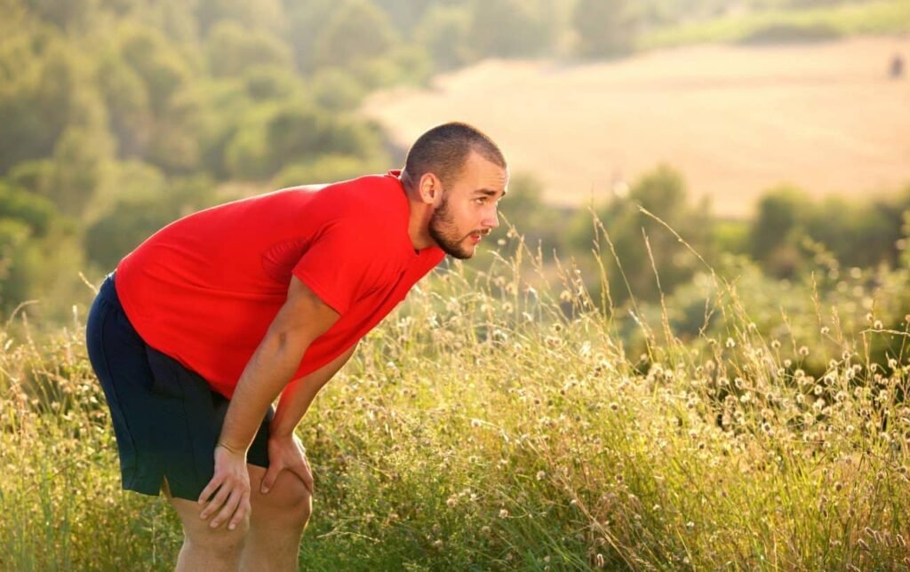 Un coureur épuisé les mains sur les genoux