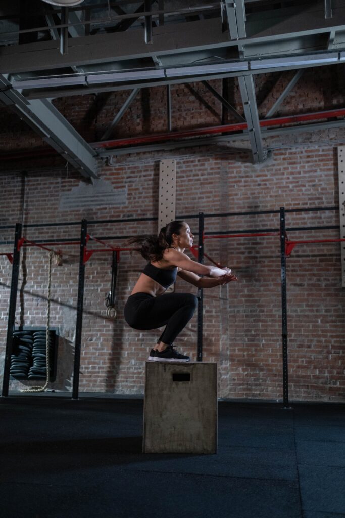 Une femme fait un squat sur une box de crossfit