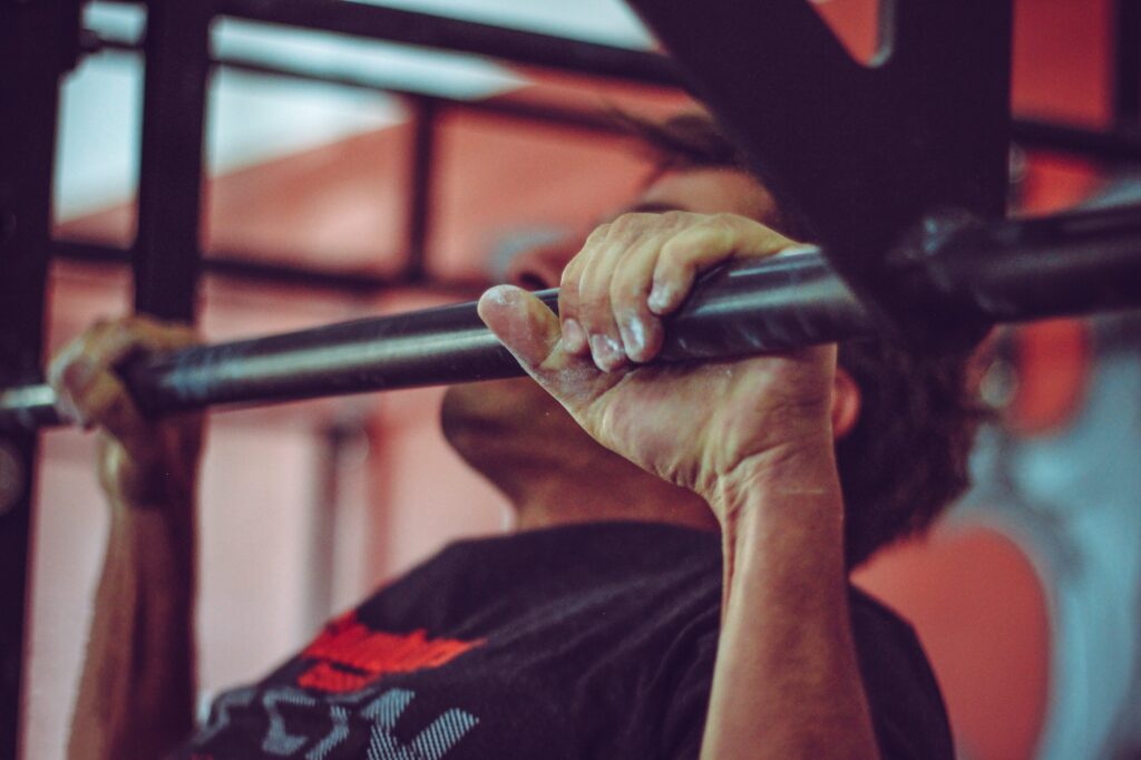 Un homme fait une traction sur une barre de musculation