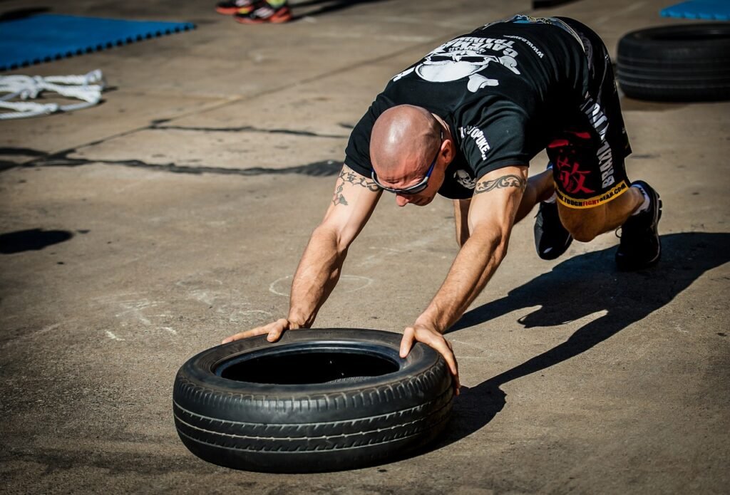 Un homme pousse un pneu au crossfit