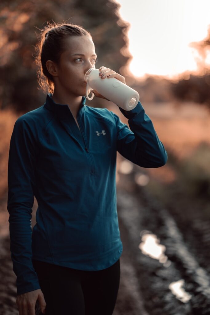 une femme boit une bouteille d'eau