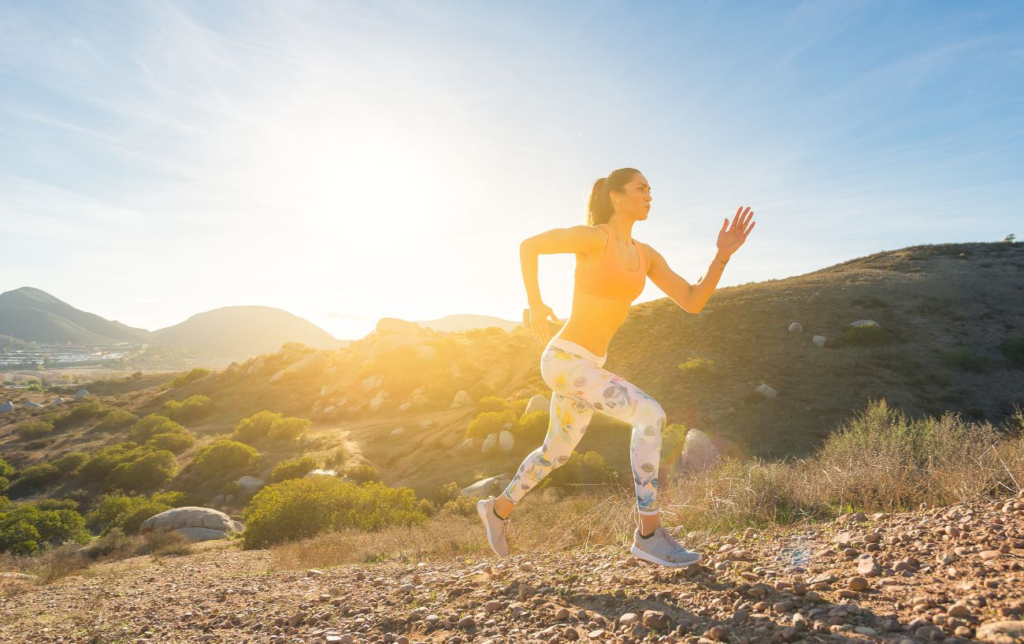 Une femme court en côte au lever du soleil