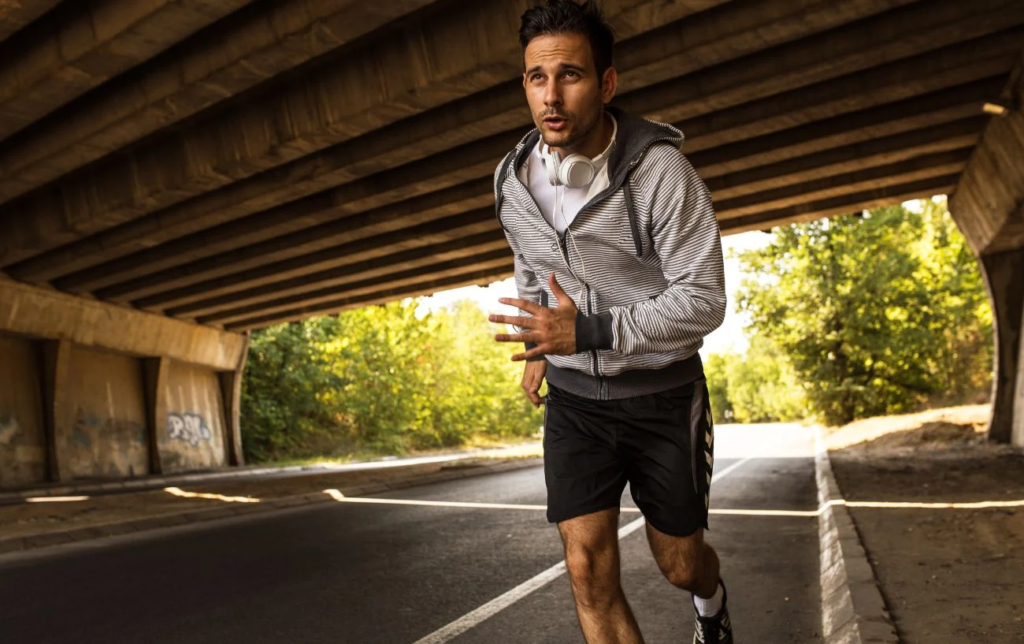Un homme court sur une route sous un pont