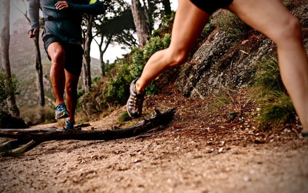 Jambes de coureurs pendant un trail en montagne