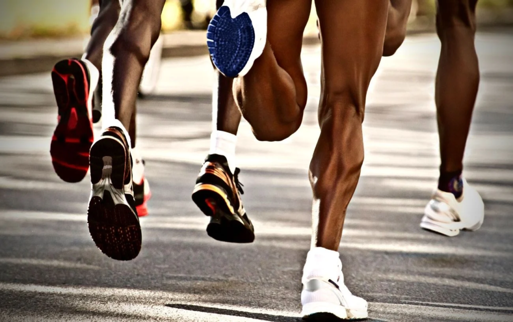 Jambes de coureurs kenyans pendant une compétition sur route
