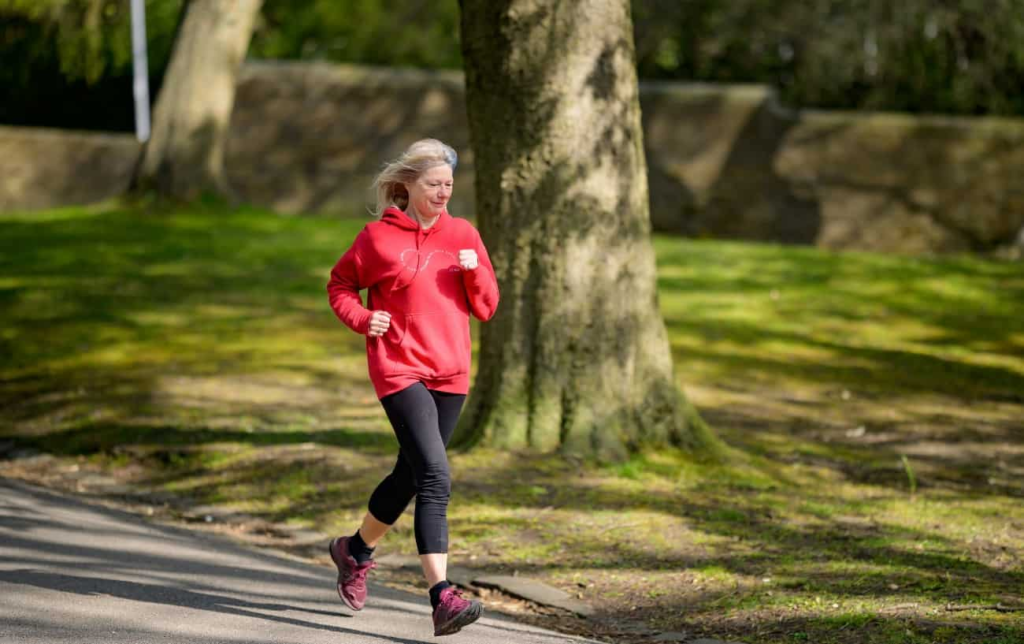 Une femme court dans un parc