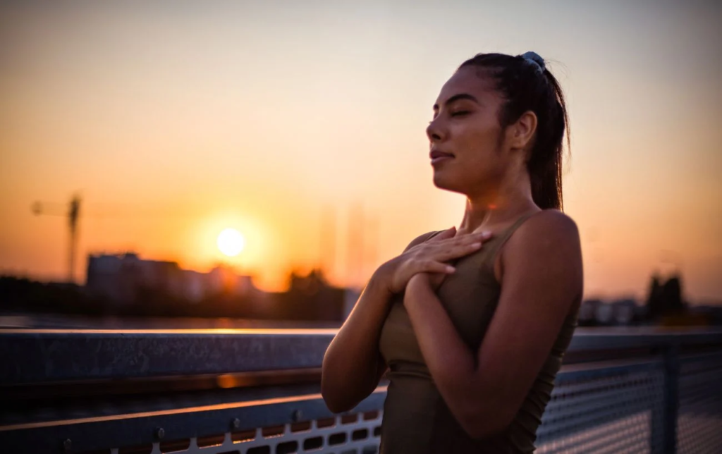 Une femme respire avec les mains sur le coeur