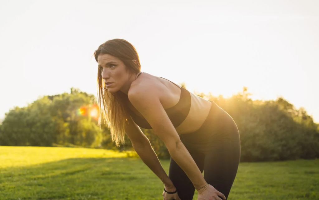 Une femme se tient les hanches après une séance running