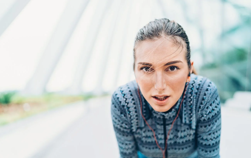 Une femme essouflée regarde l'appareil photo