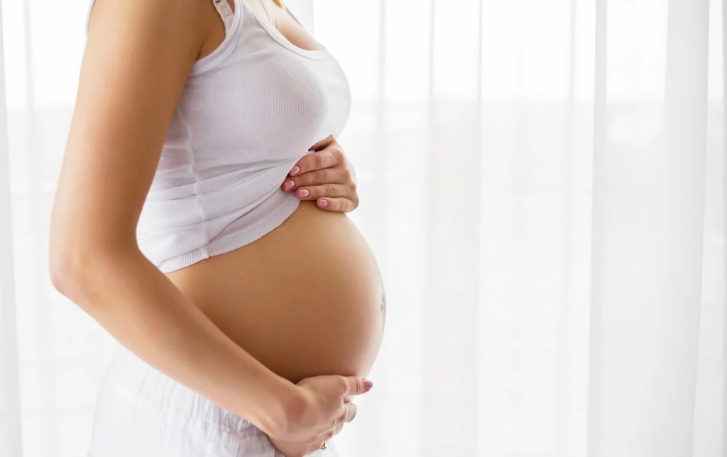 Une femme tient son ventre pendant la grossesse