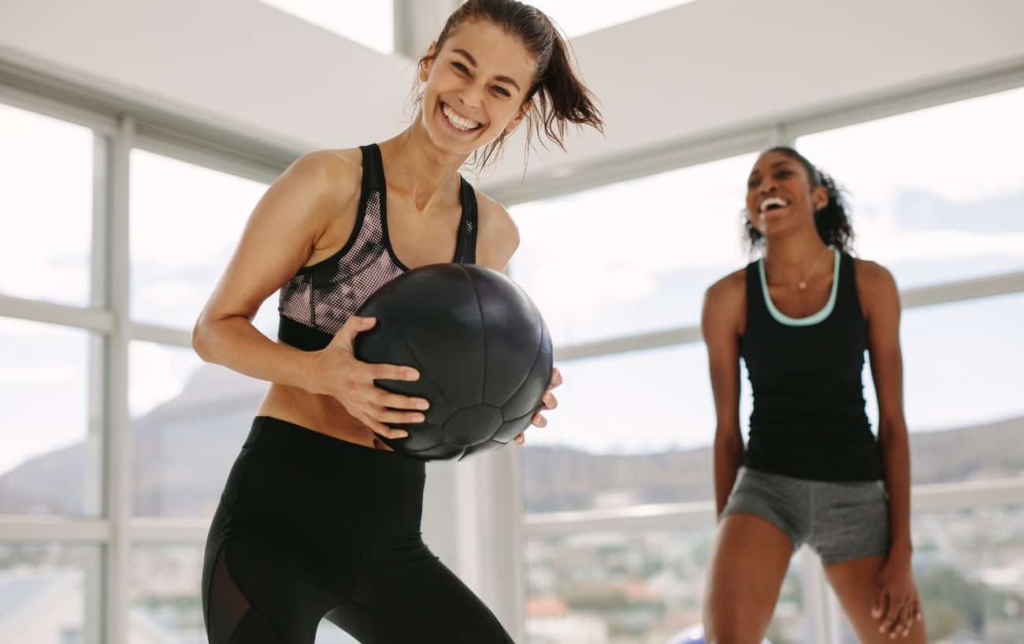 2 femmes font du renforcement musculaire et sourient