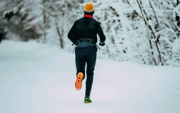 Un homme court dans la neige