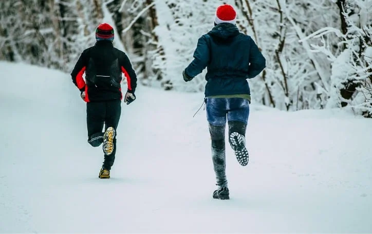 2 hommes courent dans la neige