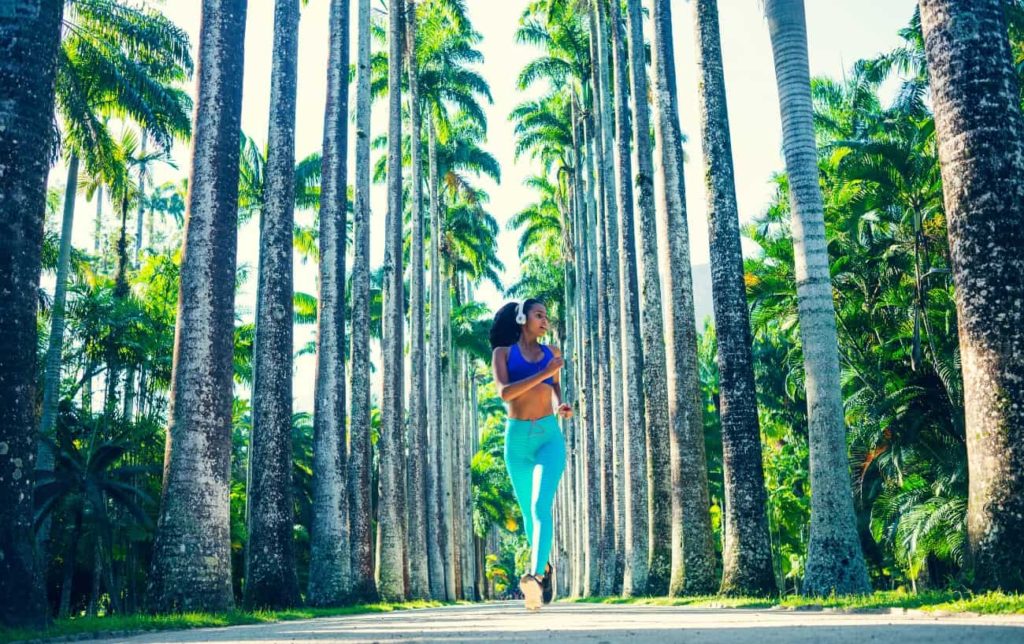 Une femme court sur une route entre des palmiers