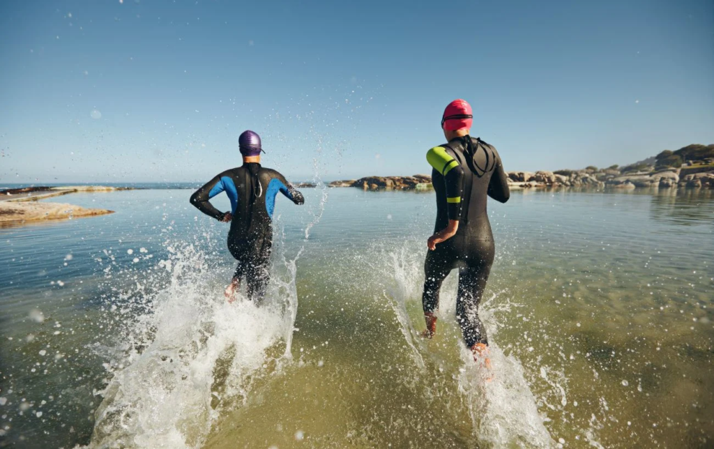 2 hommes entrent dans l'eau pendant un Ironman