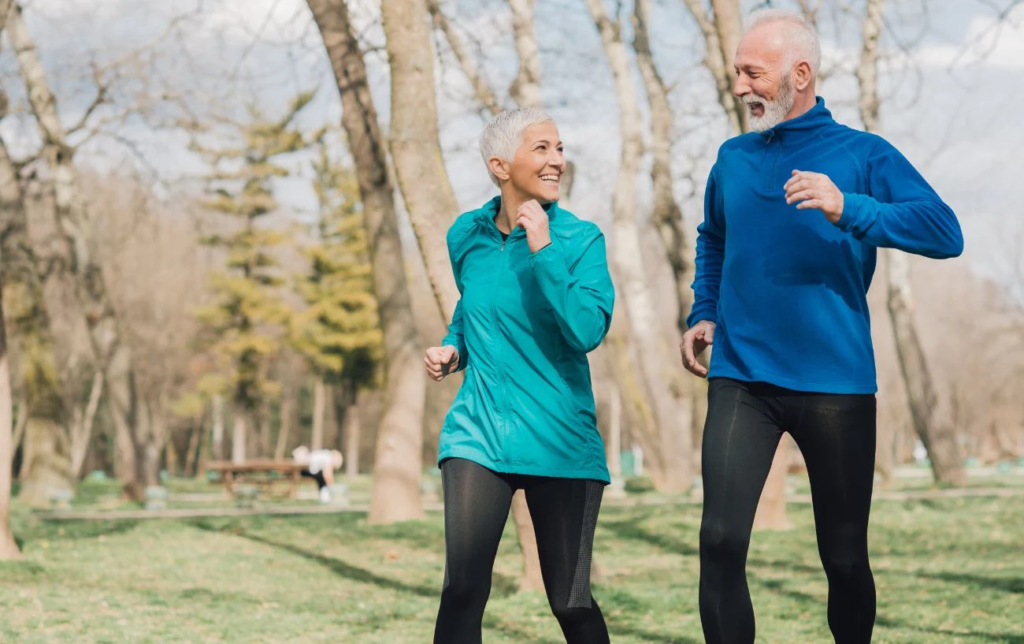 Un couple de coureurs souriant dans la forêt