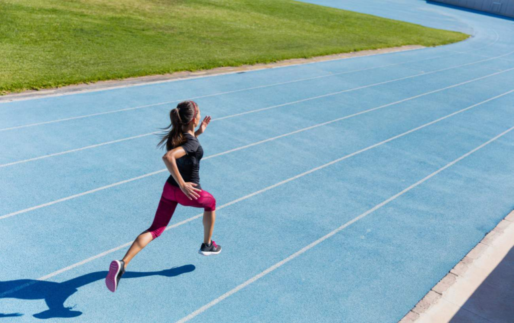 Une femme fait une séance de fractionné sur une piste d'athlétisle