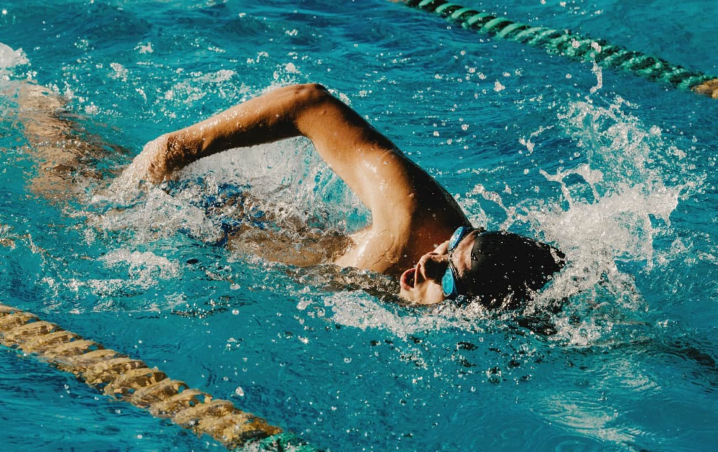 Un nageur dans une piscine fait du crawl