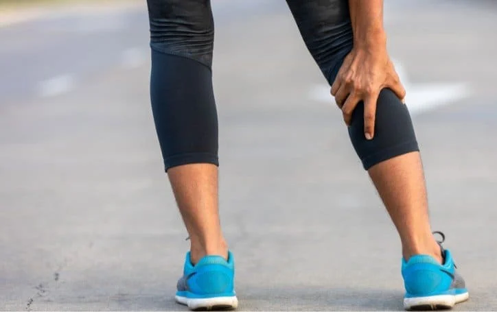 Un coureur se tient le mollet