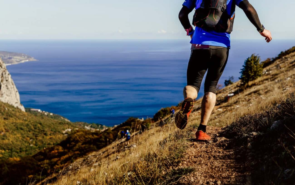 Un homme sur un sentier en montagne vue sur la mer