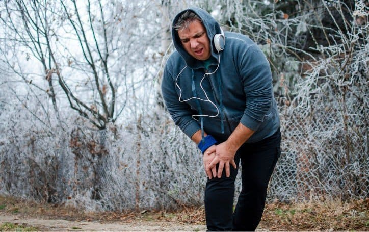 Un coureur se tient les quadriceps