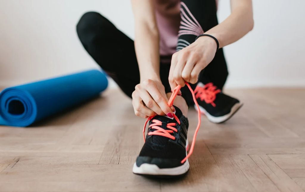 Une coureuse lace ses chaussures Asics