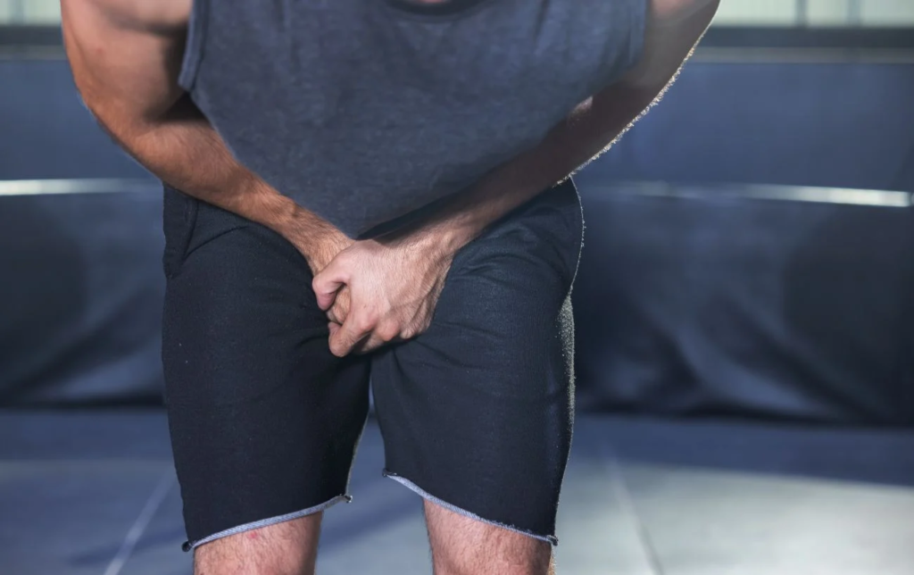 Un homme se tient le sexe