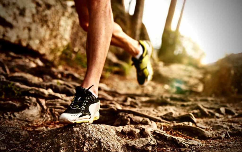 Pieds d'un coureur sur un sentier en montagne