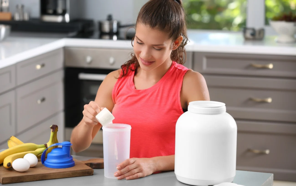 Une sportive préapare un shake protéiné dans sa cuisine
