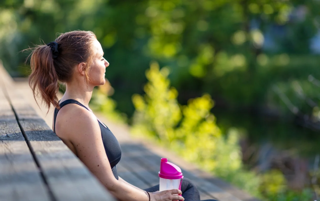 Une femme assise avec son shake protéiné