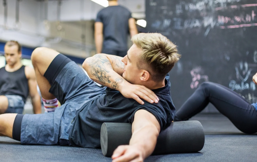 Un homme utilise un rouleau de massage sur le biceps