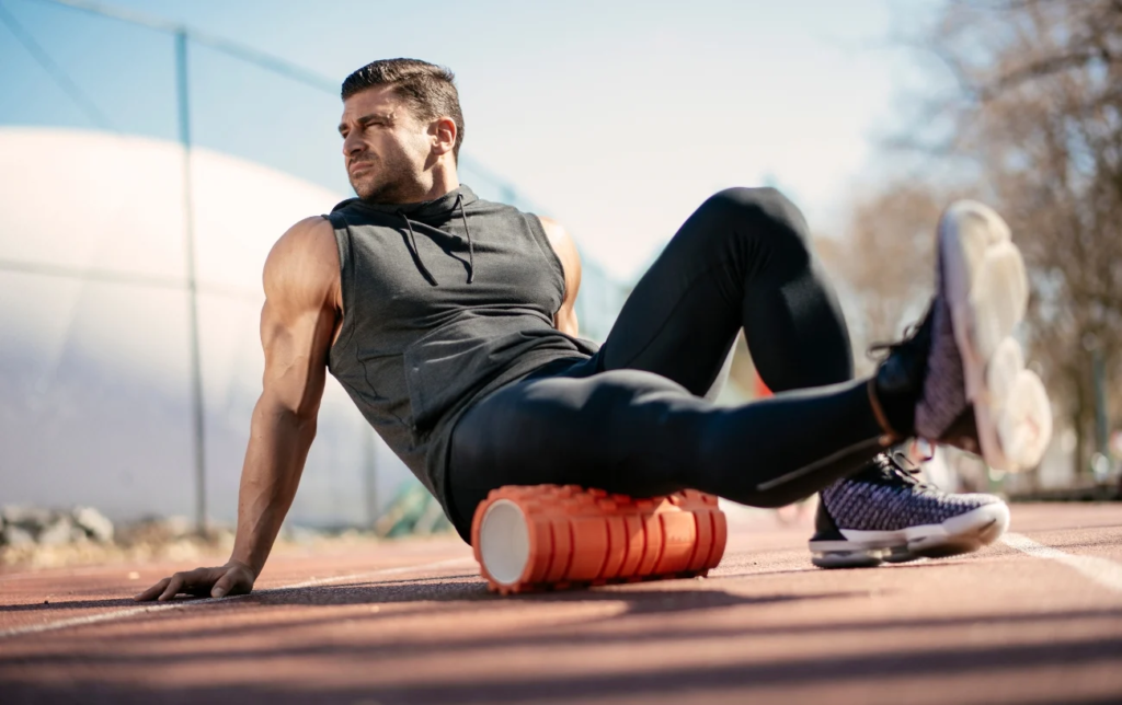 Un homme utilise un rouleau de massage sur la cuisse