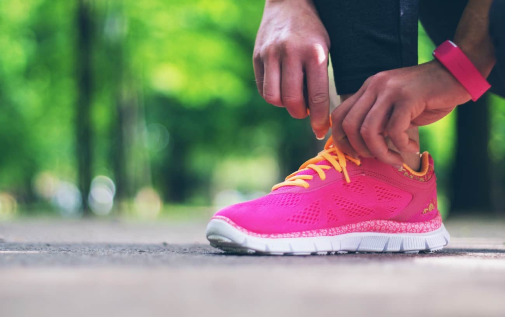 Une coureuse lace ses chaussures de running